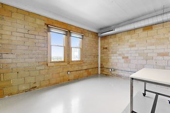 A room with a brick wall and a white table.